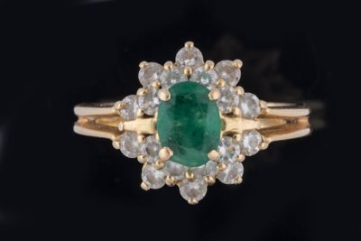 Bague marguerite centrée d’une émeraude ovale facettée dans …