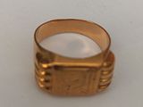 a close up of a gold ring on a white surface