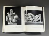 a book opened to show a black and white photo of a woman laying on a bed