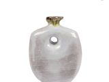 a white vase with a green top sitting on a white surface
