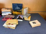 several books are stacked on a table with a blue table cloth