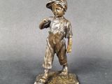 bronze figurine of a boy holding a bird on a rock