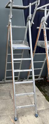 two ladders sitting next to each other on the sidewalk