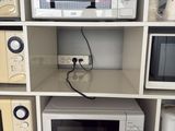 many microwaves and toasters on display in a store