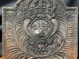 un gros plan d'une plaque en pierre sur laquelle figure une couronne