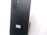 a close up of a black phone on a stand on a white surface