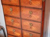 a wooden chest of drawers with a marble top