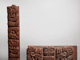 two carved wooden blocks with carvings on them sitting on a table