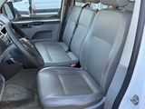 the interior of a white van with the door open and the passenger seat down