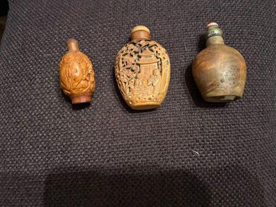 trois petits vases sont posés sur un tissu noir, sur une table