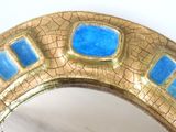 a gold and blue mirror on a white table
