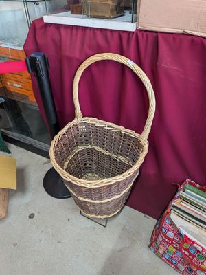 un panier en osier posé sur un support à côté d'une pile de livres
