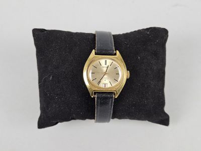 an image of a gold wrist watch on a black pillow