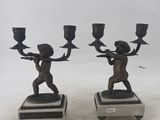 pair of bronze figurines of a boy and a girl holding a candelabra