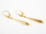 une paire de boucles d'oreilles pendantes en or sur fond blanc