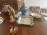 a bird sitting on a table next to a teapot and plates