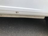 a close up of a white car with a hole in the side