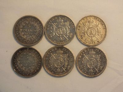 six different british coins sitting on top of a white surface