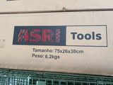 a box of tools sitting on top of a wire fence