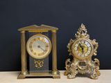deux horloges posées sur une table, avec un mur noir en arrière-plan
