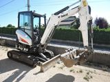 a small excavator that is parked on the side of the road