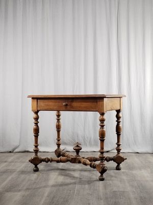 une vieille table en bois posée sur un parquet en bois dur