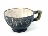 a black cup with writing on it on a white surface