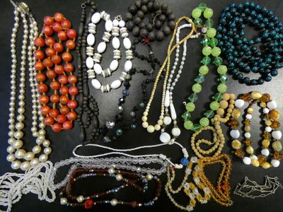 a lot of beads and necklaces that are on a table