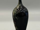 a black vase that has a floral design on it