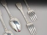four silver spoons and a fork are lined up on a table