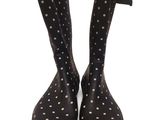 des bottes de pluie noires ornées de pois blancs sur fond blanc