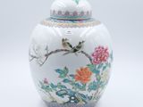 un vase blanc sur lequel sont peints un oiseau et des fleurs