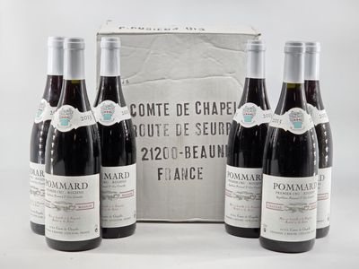 three bottles of wine are sitting in front of a cardboard box