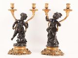 pair of antique bronze figurines of a boy and a girl holding candles