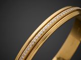 a close up of a gold bang with diamonds on a black background