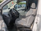 the interior of a white van with grey seats and a steering wheel