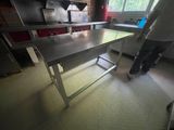 un homme debout dans une cuisine où se trouve une table