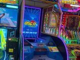 plusieurs bornes d'arcade dans une salle éclairée par des néons