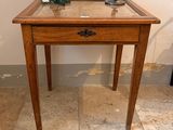 a small wooden table with a lamp on top of it