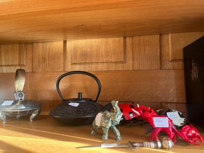 une étagère en bois sur laquelle sont posés une bouilloire et d'autres objets