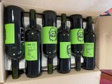 six bottles of wine in a cardboard box on a table
