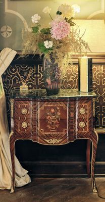 une table sur laquelle se trouve un vase de fleurs