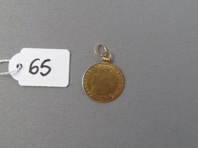 une pièce d'or sur laquelle figure un chiffre, à côté d'une étiquette de prix