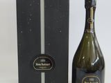 the bottle of champagne is next to the black box