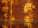 a glass display case with flowers and leaves on it