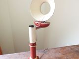 a red and white lamp on a wooden table