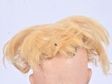doll with blonde hair and suspenders on a white background