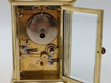 a gold clock with a mirror in the middle of it