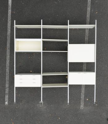an overhead view of a white bookcase with drawers and shelves