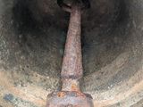 a large metal bell with a rusted handle on it